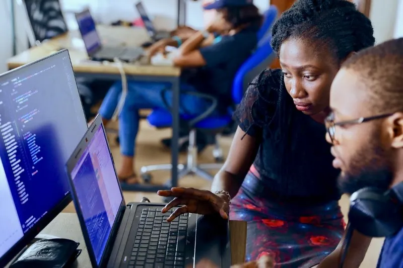 Two people collaborating by a computer