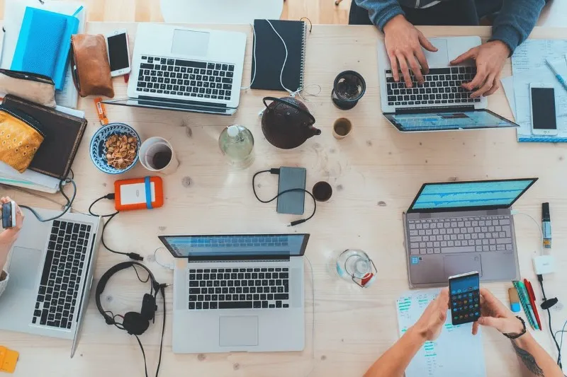 Image of a desk with several laptops on it